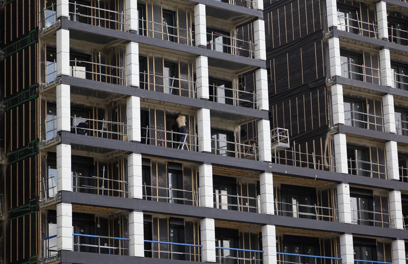 Immeuble en construction avec échafaudages et ouvriers