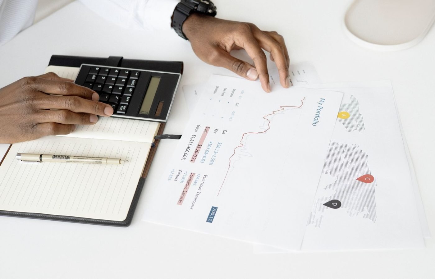 Mains d'une personne relisant des documents comptables avec une calculatrice