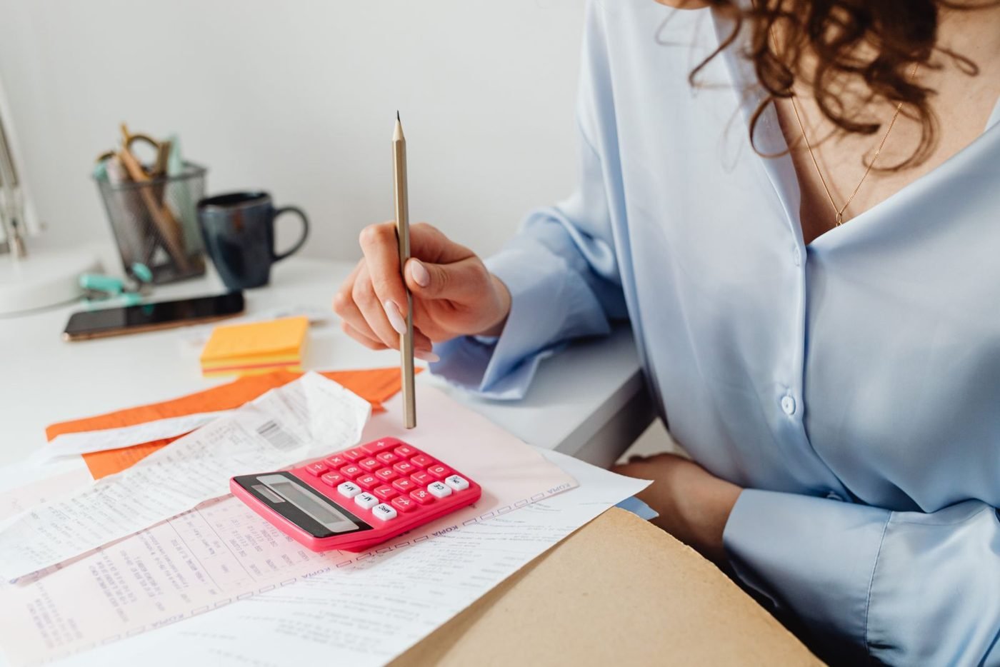 Femme calculant des dépenses à son bureau avec des factures