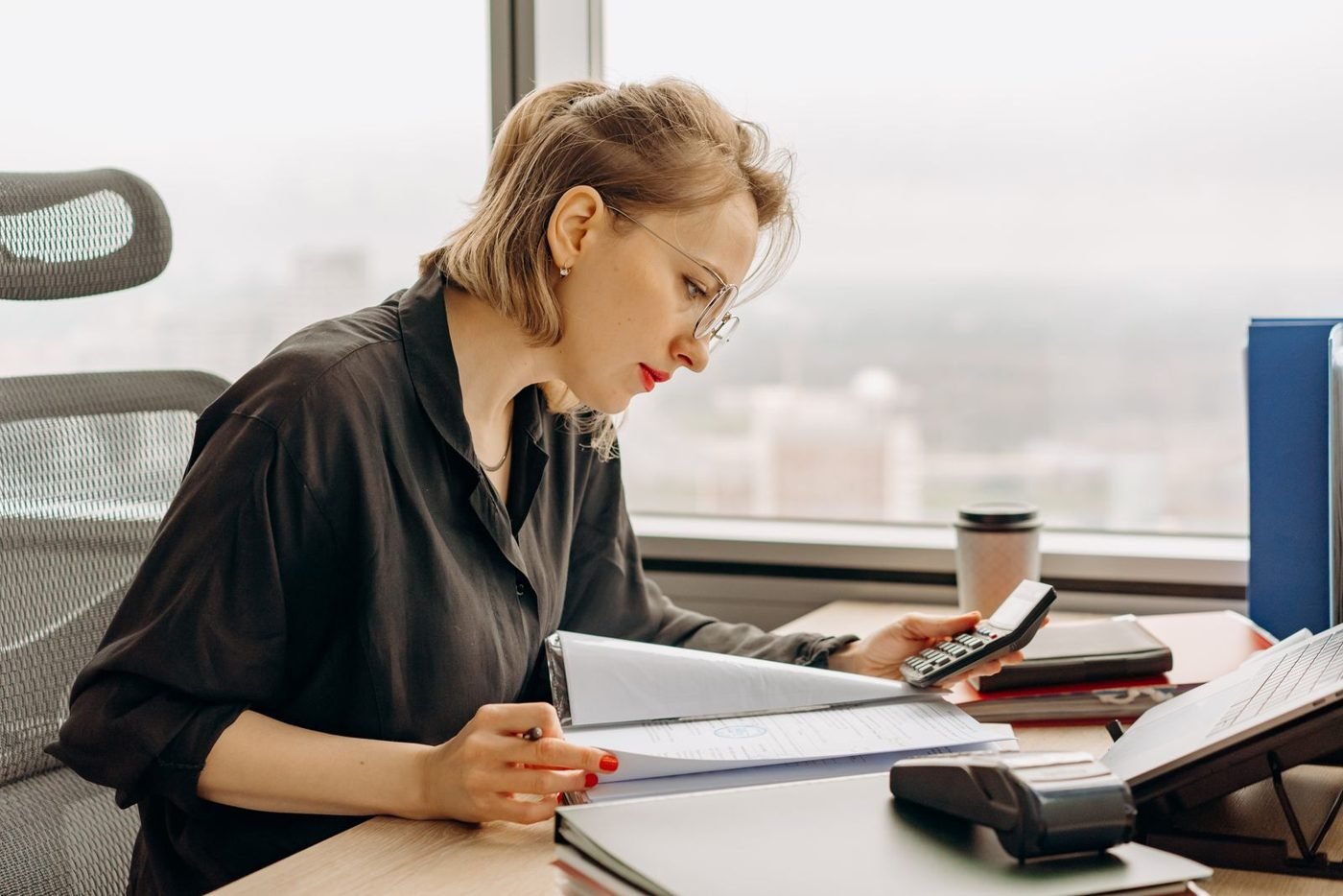 Femme comptable travaillant sur des documents financiers au bureau