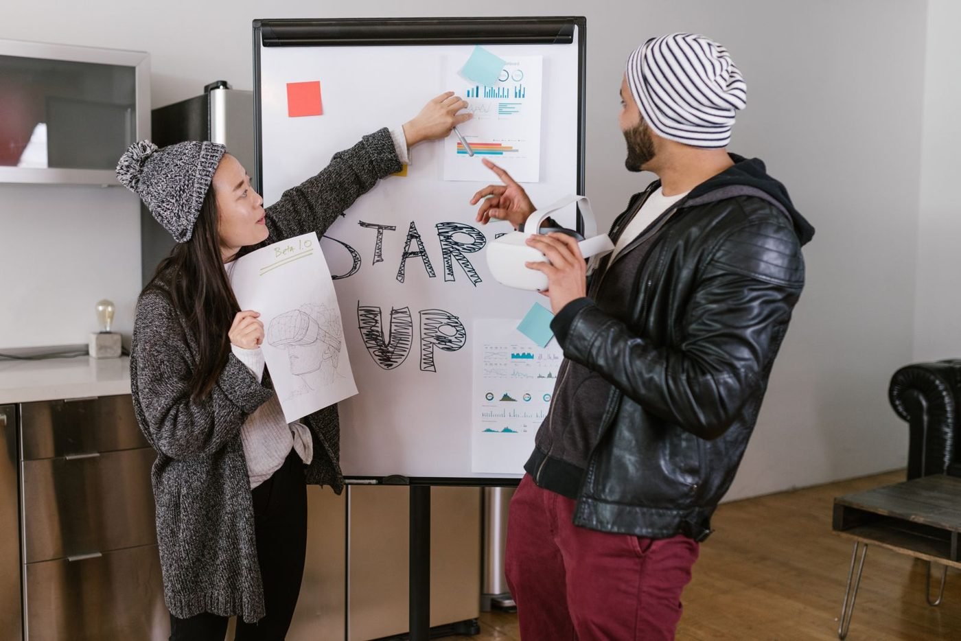 Deux jeunes entrepreneurs présentant leur projet sur un paperboard