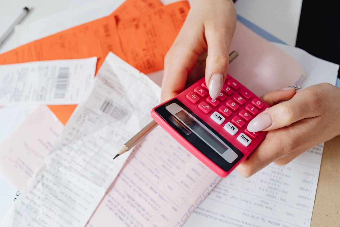 Mains utilisant une calculatrice avec des reçus