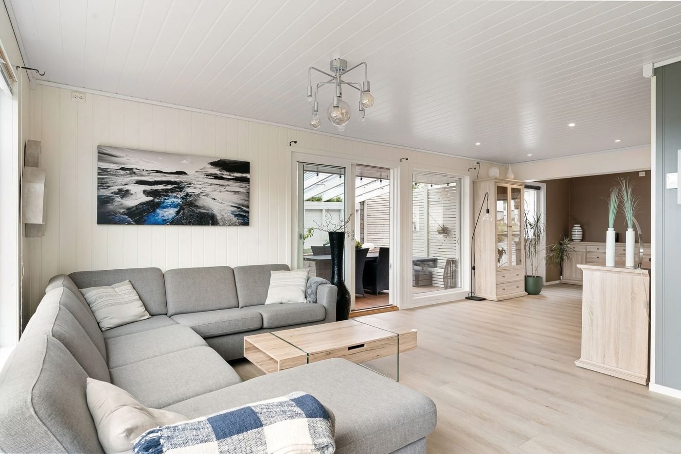 Salon lumineux avec un canapé gris et une décoration minimaliste