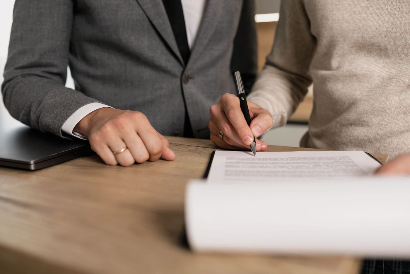 Deux personnes signant des documents à un bureau