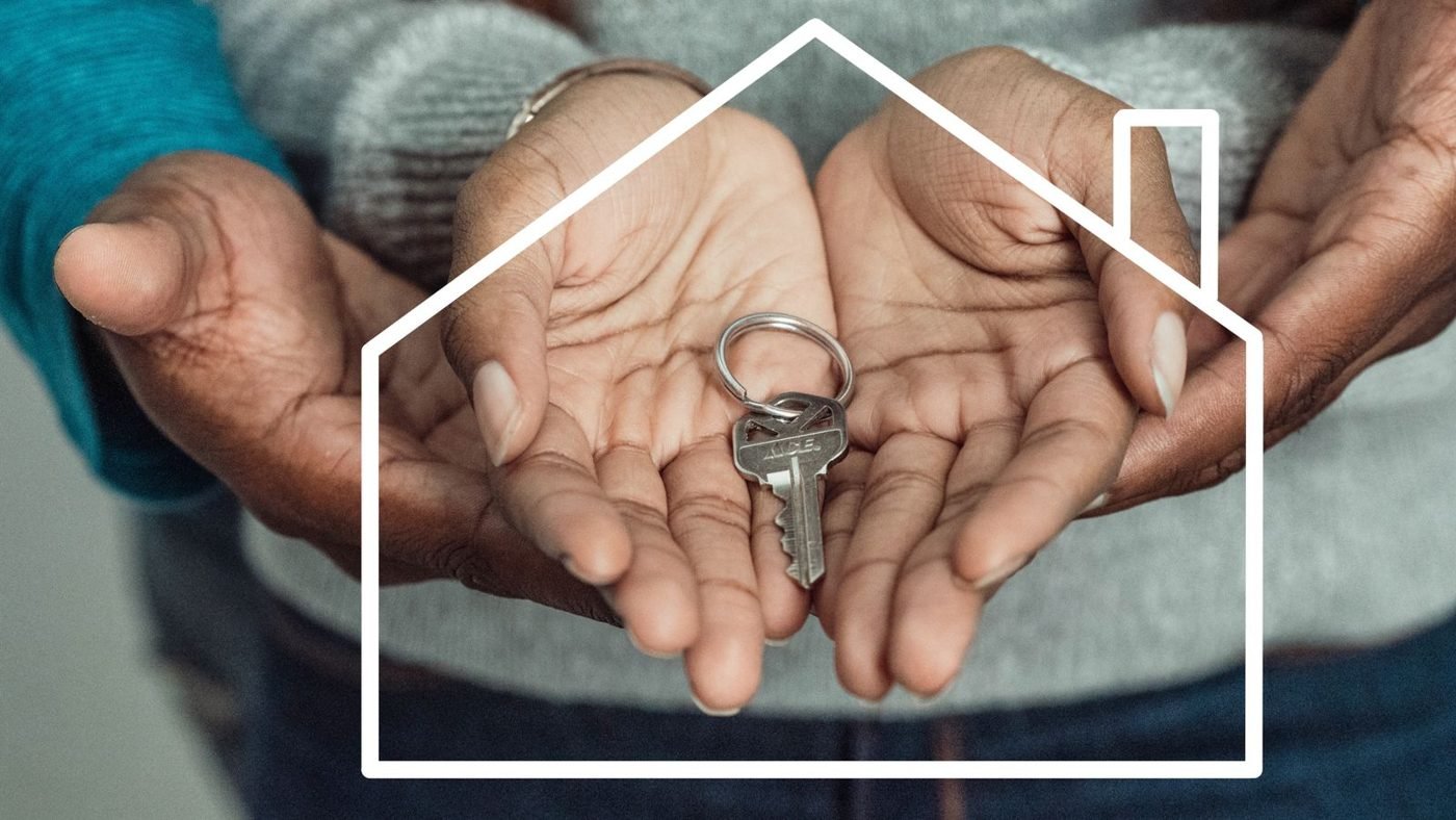 Mains d'un couple tenant une clé de maison symbolisant un nouvel investissement