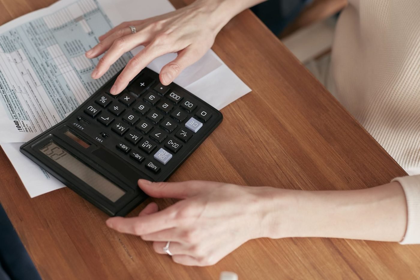 Femme examinant des documents financiers avec une calculatrice
