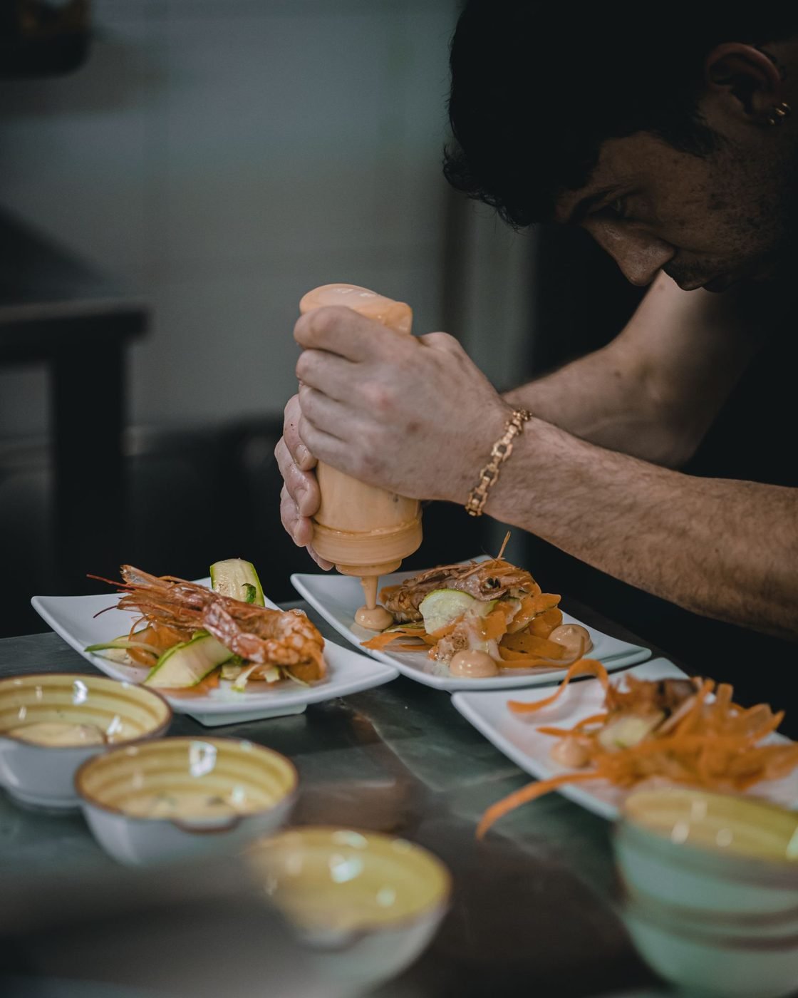 Un chef prépare un plat de fruits de mer dans une cuisine de restaurant
