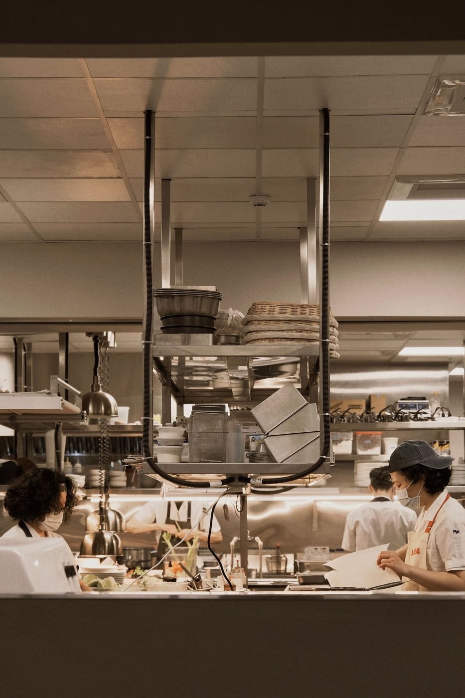 Des chefs dans une cuisine de restaurant animée préparant des repas avec précision et esprit d'équipe