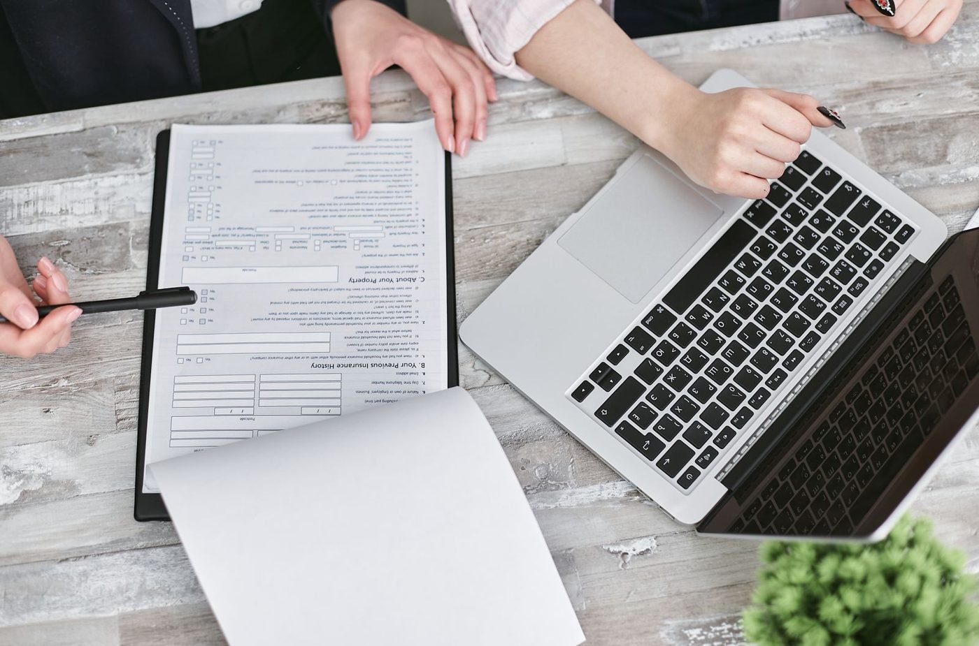 Deux professionnels collaborant sur des documents et un ordinateur portable